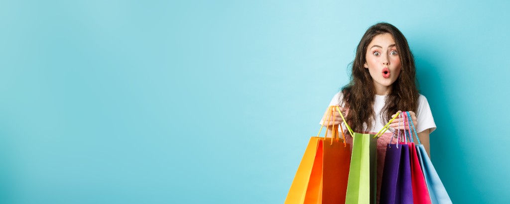 Amazed shopper holding colorful shopping bags